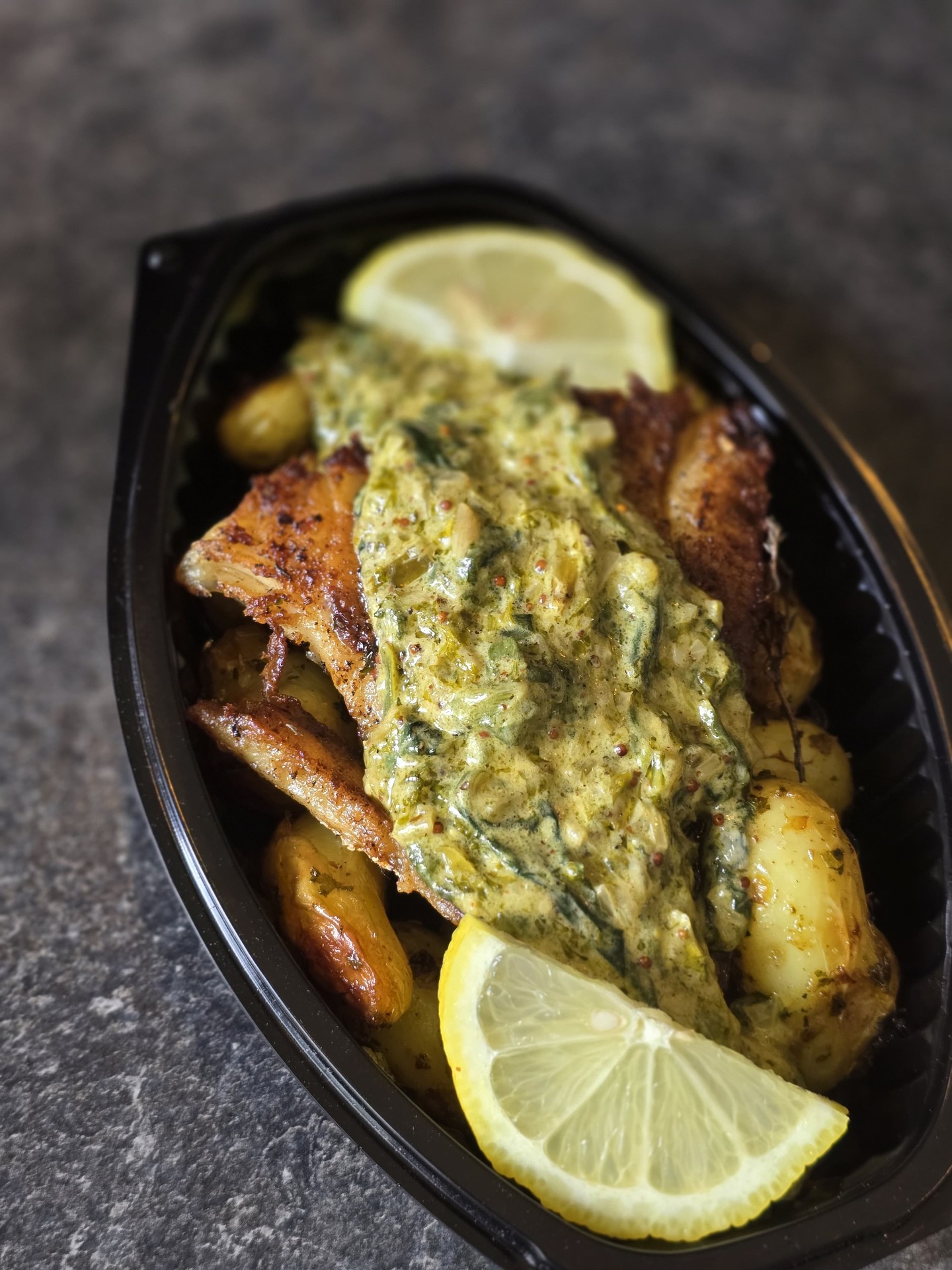 Poulet rôti, sauce aux herbes, pommes de terre et citron en barquette